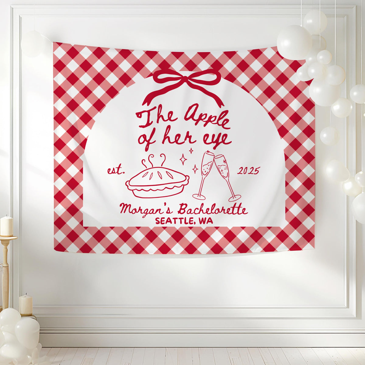 Red and pink apple themed bachelorette party banner with bow champagne glasses and personalized party details
