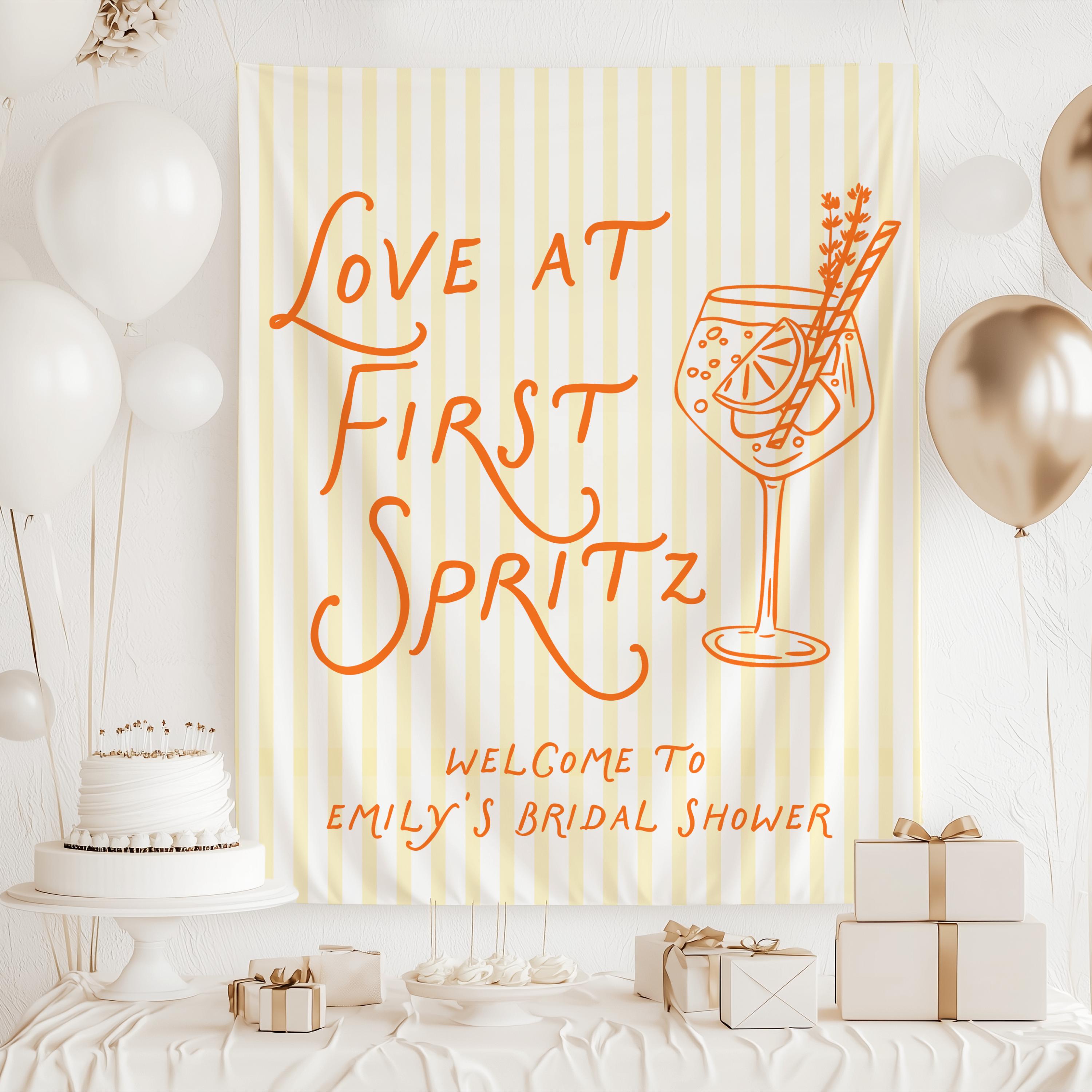 Love at First Spritz bridal shower banner hanging as party backdrop with personalized welcome message