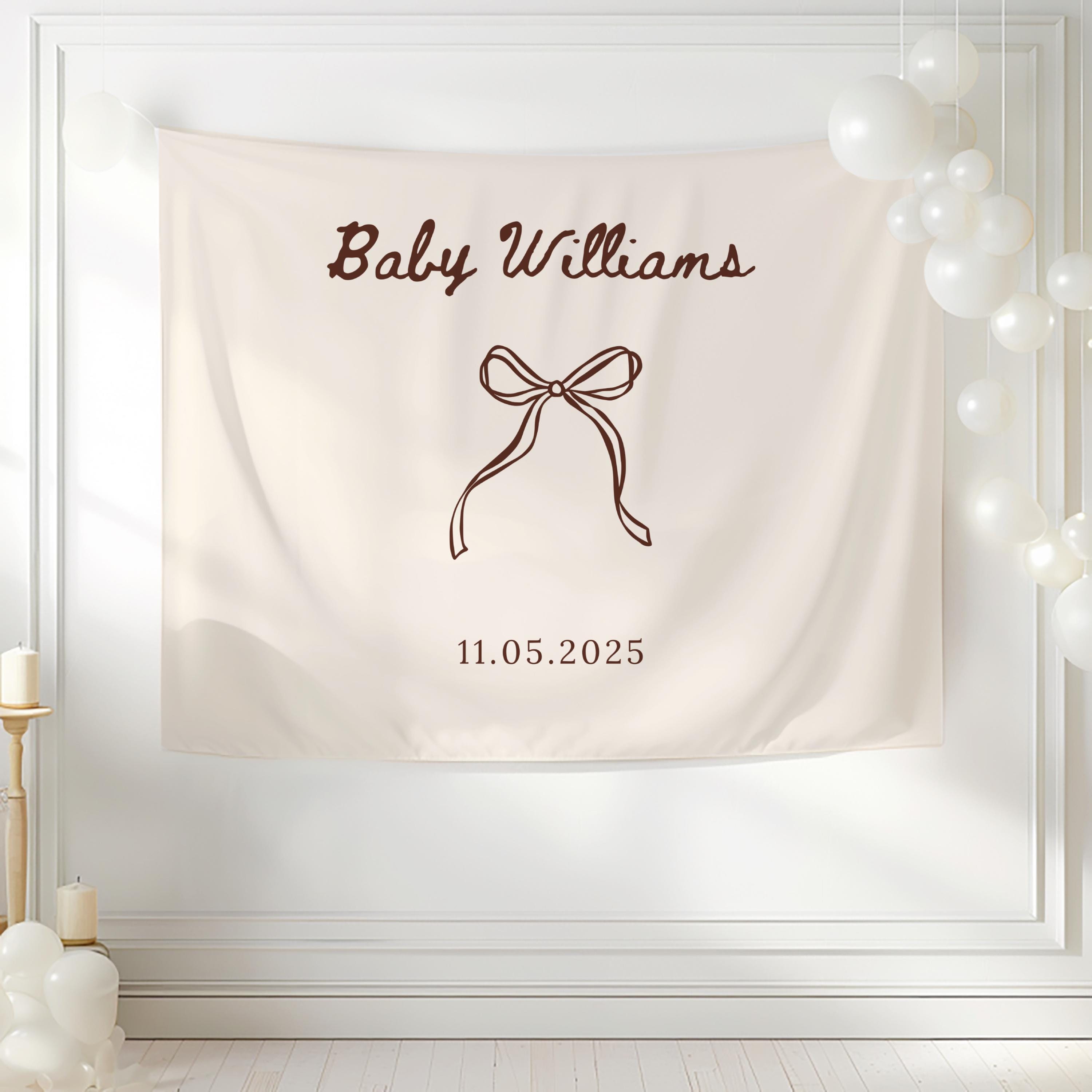 Personalized baby shower tapestry used as a stylish photo booth backdrop for modern baby shower celebrations.