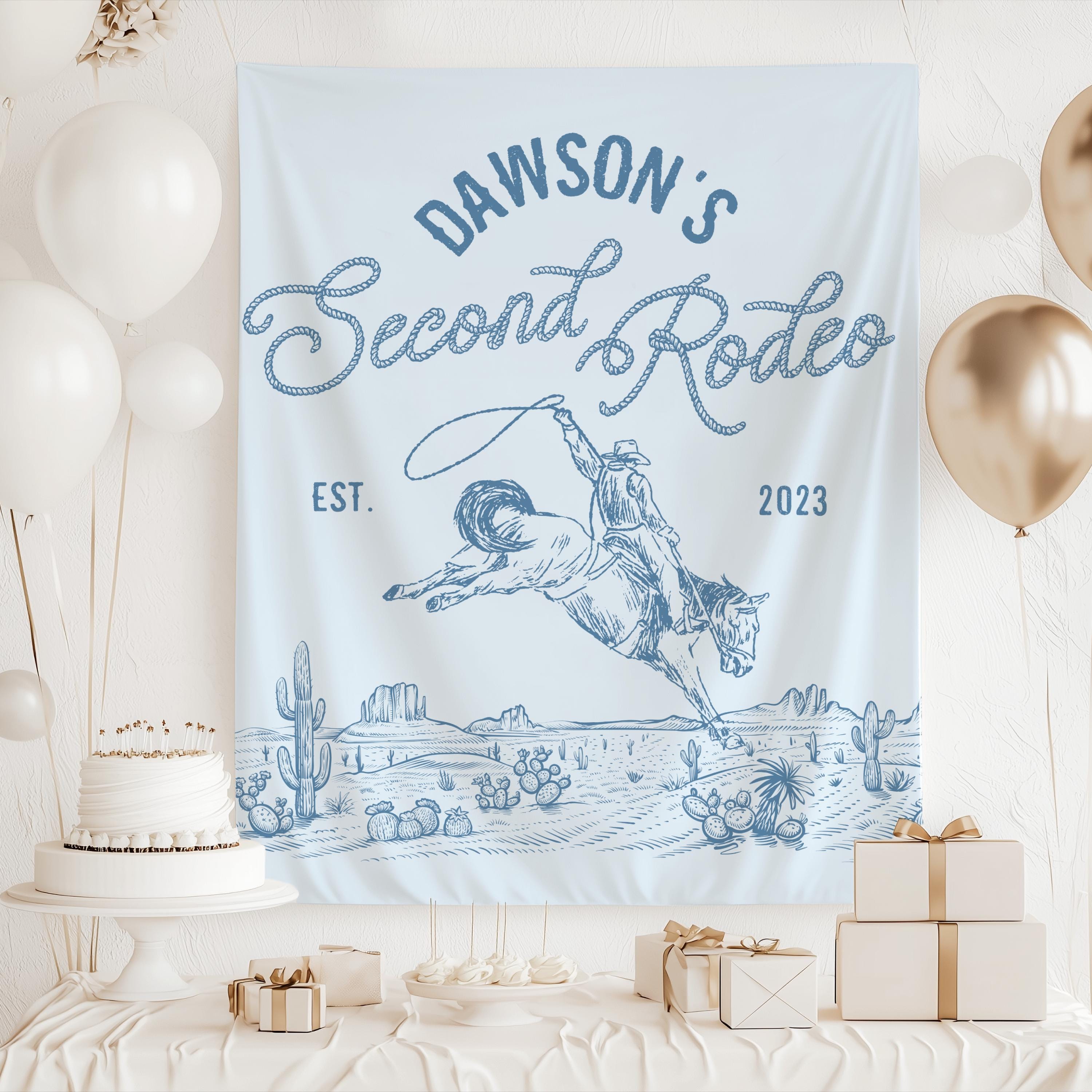 Cowboy cake smash backdrop featuring western rodeo artwork and personalized second birthday celebration details.
