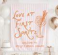 Personalized Love at First Spritz bridal shower welcome banner with pink striped background and orange cocktail illustration
