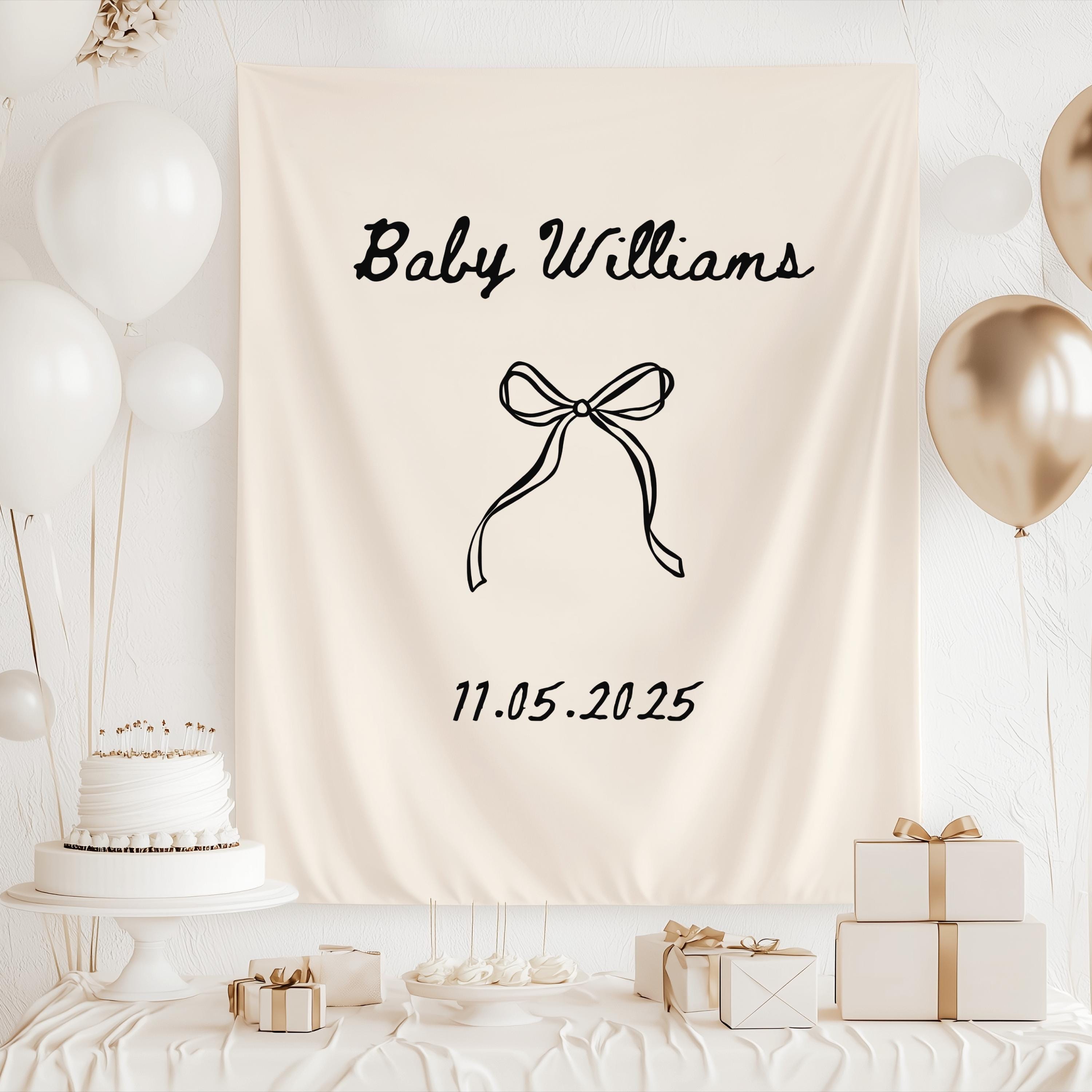 Neutral baby shower tapestry featuring a personalized baby name and simple bow design for classic baby shower decor.