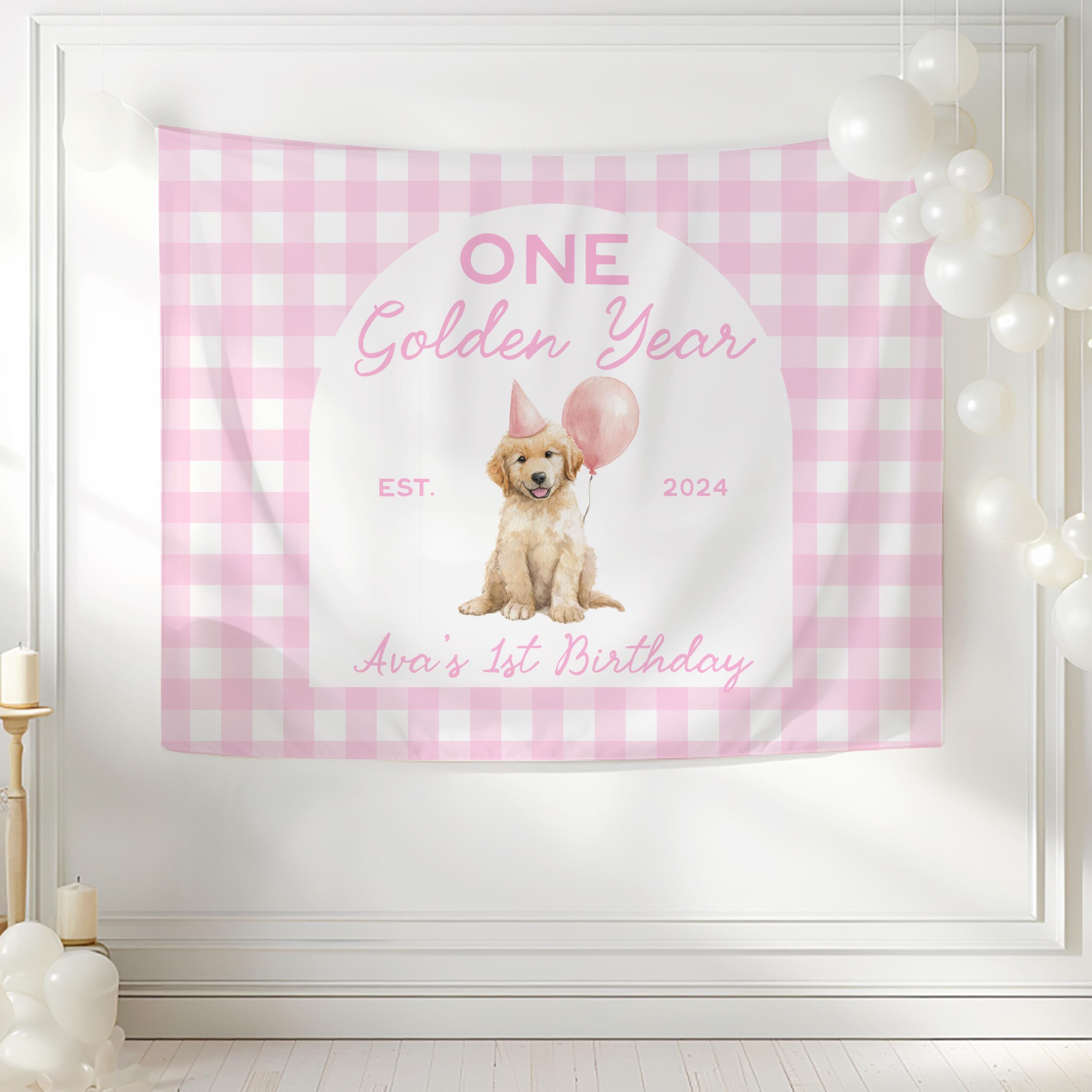 ONE Golden Year birthday backdrop featuring a golden retriever puppy wearing a party hat with personalized first birthday details.