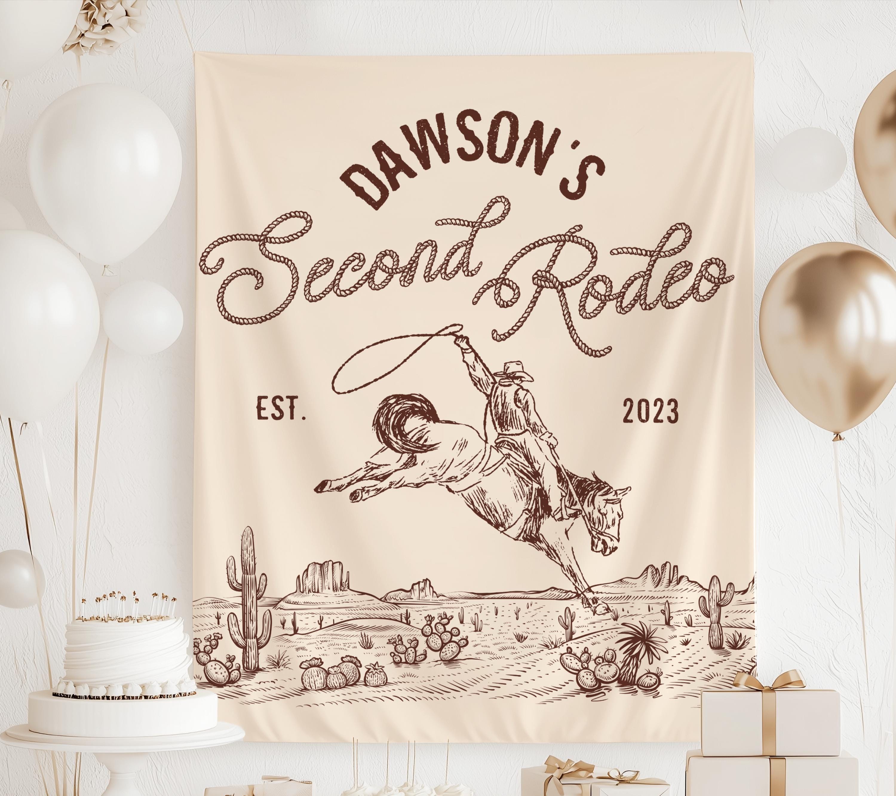 Personalized Second Rodeo backdrop with vintage cowboy illustration, cacti and western themed second birthday decorations.