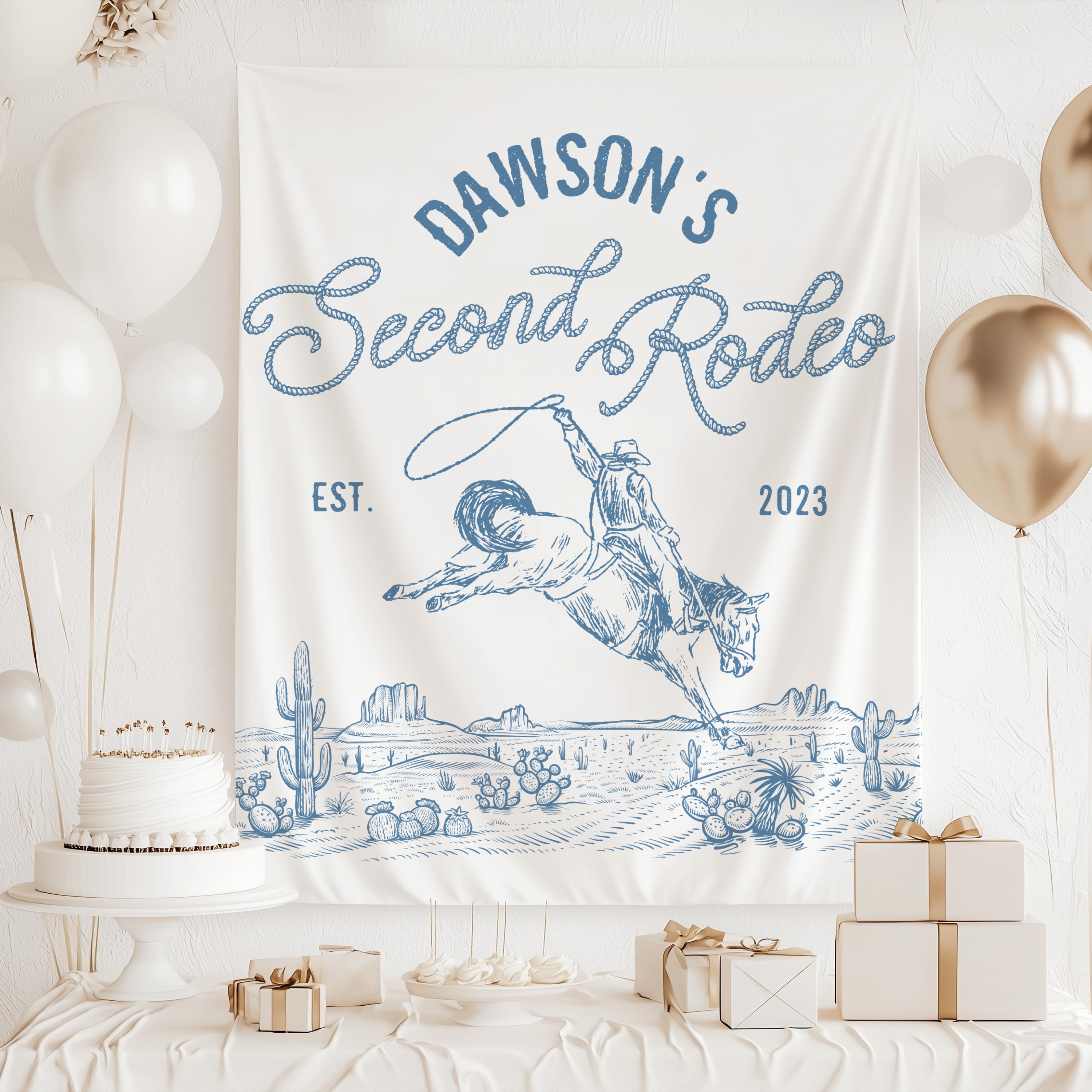 Western second birthday backdrop with bucking bronco, cowboy illustration and personalized rodeo birthday decorations.